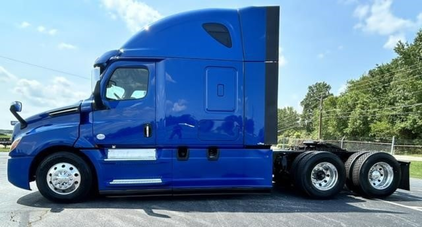 Blue Freightliner Cascadia 126 tractor side view showing sleeper cab, fuel tanks, and chrome wheels.