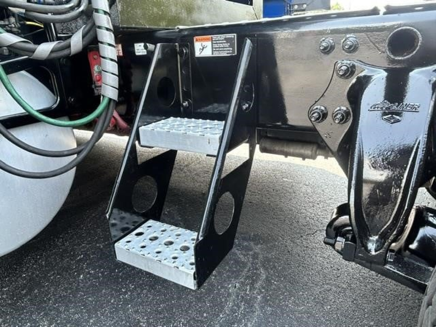 Truck step ladder and frame of a Freightliner Cascadia 126 undercarriage showing metal steps and mounting brackets.