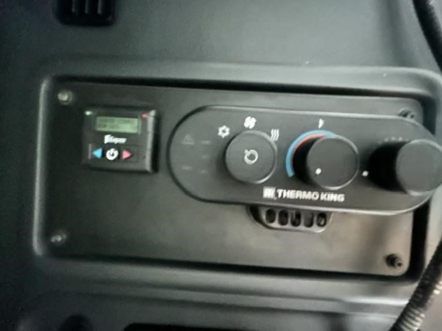 Dashboard panel of a Freightliner Cascadia cab showing Thermo King climate control with knobs and display.