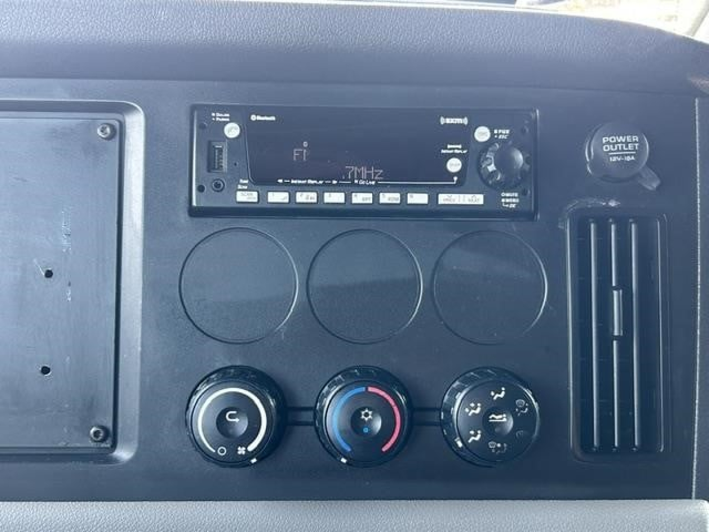 Dashboard and control panel of a Freightliner Cascadia 126 shows radio/navigation unit and climate controls.