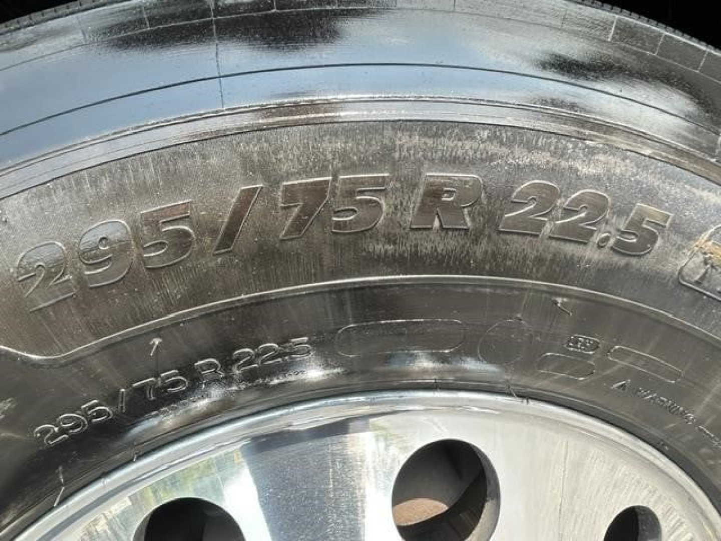 Tire sidewall with 295/75 R22.5 markings and wheel hub visible.