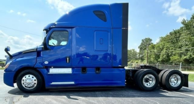 Blue Freightliner Cascadia 126 tractor side view showing sleeper cab, fuel tanks, and chrome wheels.