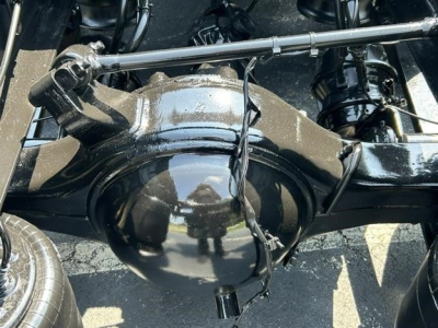 Axle housing and differential in a Freightliner Cascadia chassis showing the rear suspension area and drive shaft components.