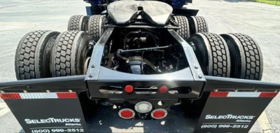 Rear view of a Freightliner truck chassis showing dual rear axles, fifth-wheel area, and bumper with Reflectors and taillights. License plates not visible.