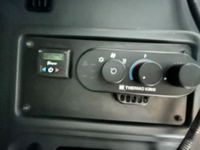 Dashboard panel of a Freightliner Cascadia cab showing Thermo King climate control with knobs and display.