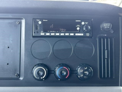 Dashboard and control panel of a Freightliner Cascadia 126 shows radio/navigation unit and climate controls.
