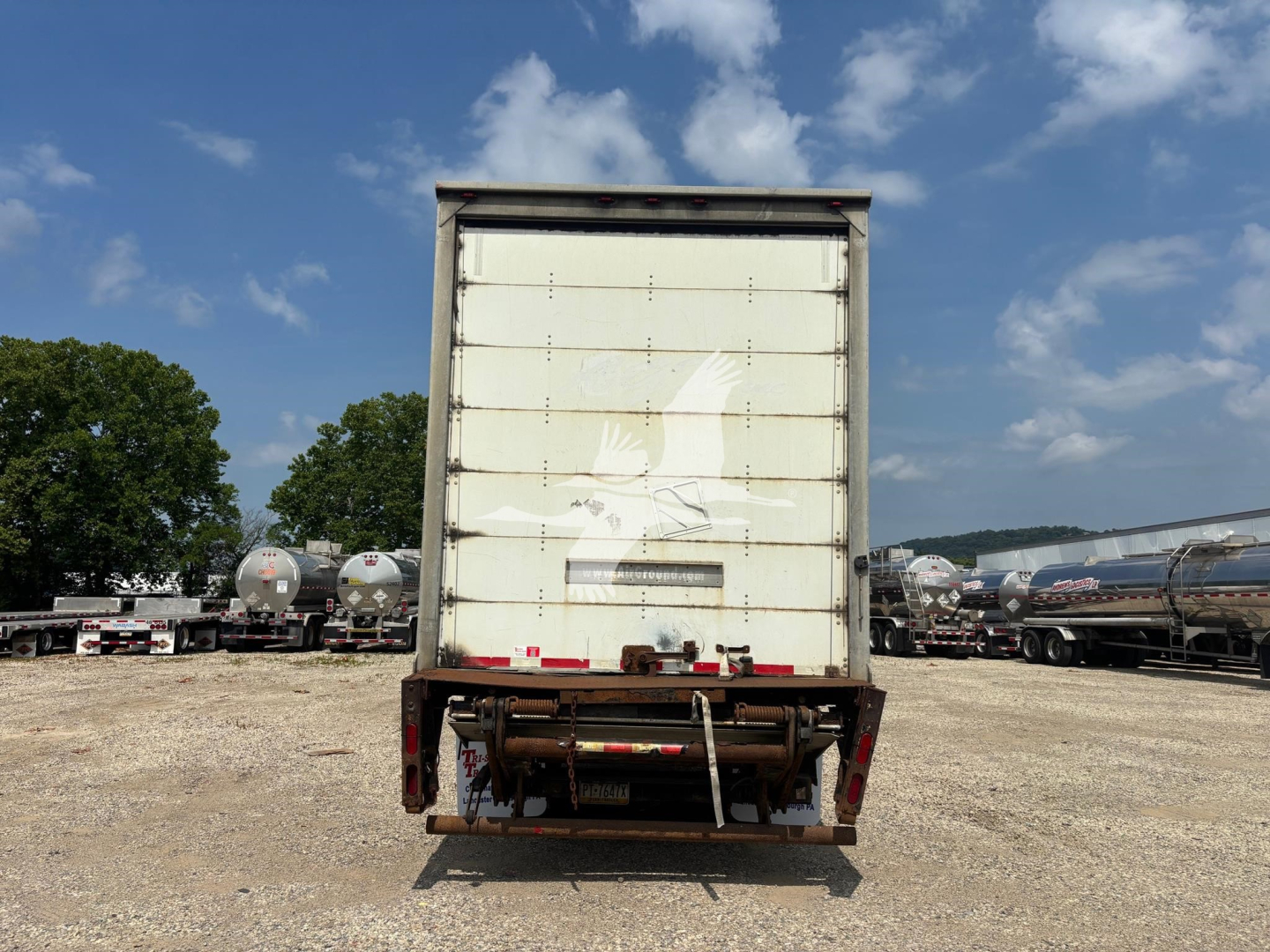 Rear view of a 2015 Wabash trailer with closed box, white back door, and bumper steps visible. VIN 1JJV532D5FL843019 implied by listing. Stock 7670.
