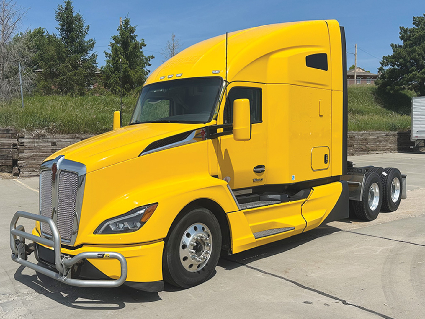 Kenworth T680 Next Gen tractor in yellow, front three-quarter view, cab with aerodynamic styling and dual rear axles.