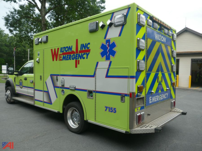 Ambulance side and rear showing bright lime green exterior with Wilton Emergency lettering and reflective chevron pattern.