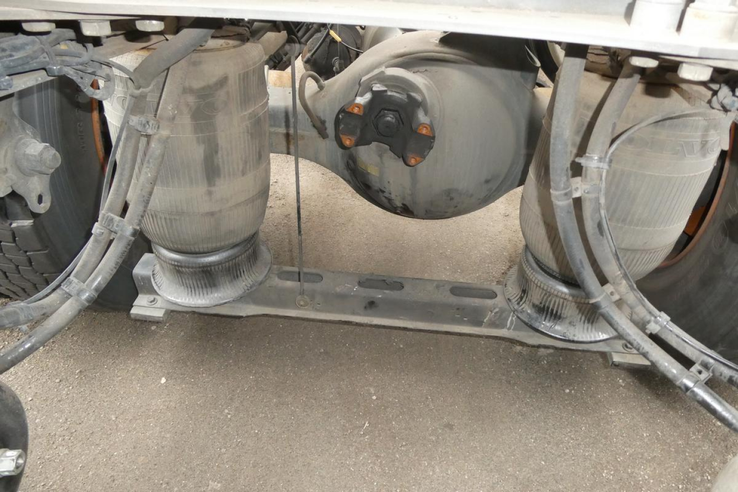 Rear view under a Volvo VNM64T truck showing twin air tanks and chassis components