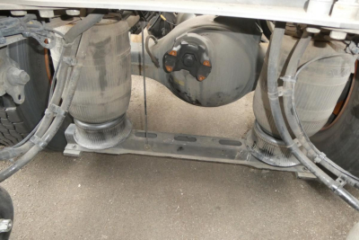 Rear view under a Volvo VNM64T truck showing twin air tanks and chassis components