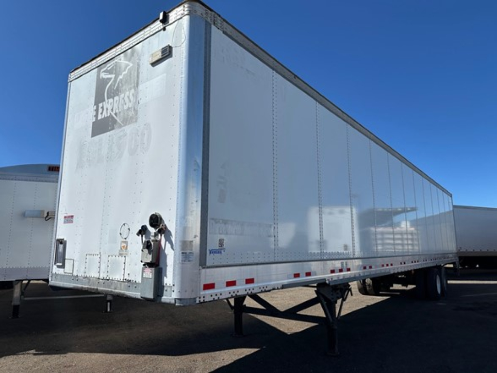 Trailer side and rear showing Vanguard dry van with roll-up door and lettering on front corner.