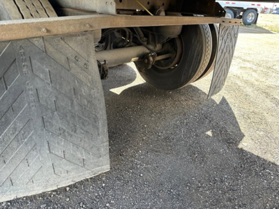 Trailer close-up showing rear wheels, drivetrain and mudflaps. Text visible on mudflap reads 'RACK BEAM' and there are structural components undercarriage. No other legible markings.