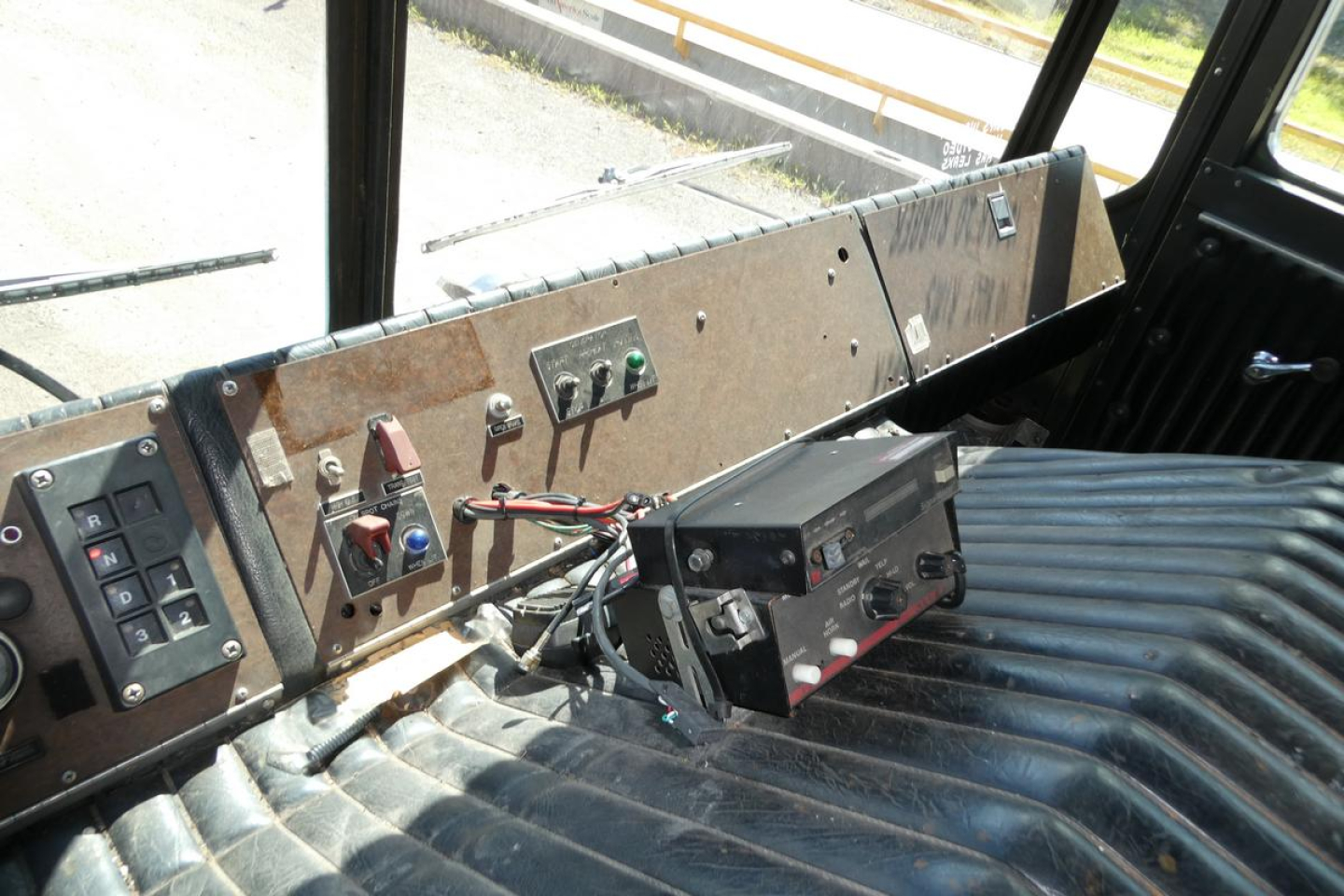 Dashboard area of a 1991 KME fire truck interior showing control switches and a mounted device on a ribbed metal panel.