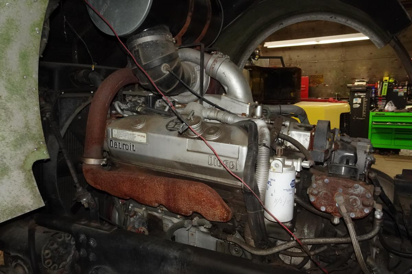 Fire truck engine bay showing inline diesel engine with Delmotype markings and red exhaust manifold hoses.