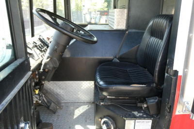 Cab interior of a 1991 KME fire truck showing steering wheel, driver's seat, and dashboard area.