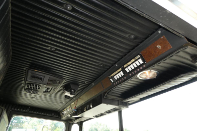 Fire truck cabin ceiling showing control panel with switches and gauges and overhead vent/grille.