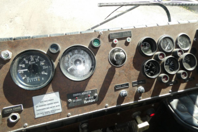 Dashboard panel of a 1991 KME fire truck showing gauges and switches, incl. speedometer, tachometer, and multiple circular gauges; vintage metal panel with labels.
