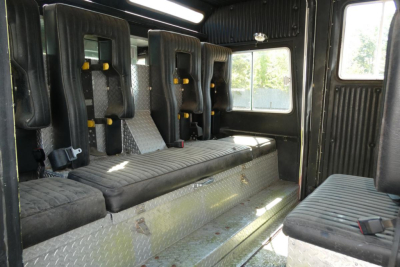 Interior of 1991 KME fire truck showing seating and cabin with diamond plate floor and black seats.