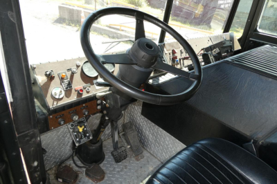 Interior of a 1991 KME fire truck cab showing steering wheel, dashboard with gauges, pedals, and diamond plate floor.