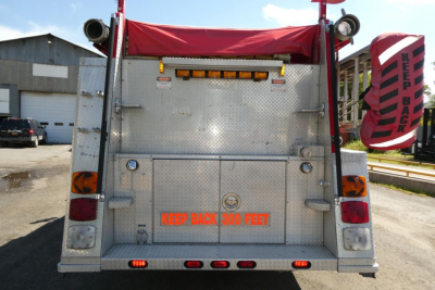 Rear view of 1991 KME fire truck showing metallic tailgate with 'KEEP BACK 300 FEET' text and rear lights.