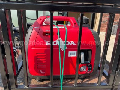 Red portable generator inside a fenced framework showing control panel and fuel cap.