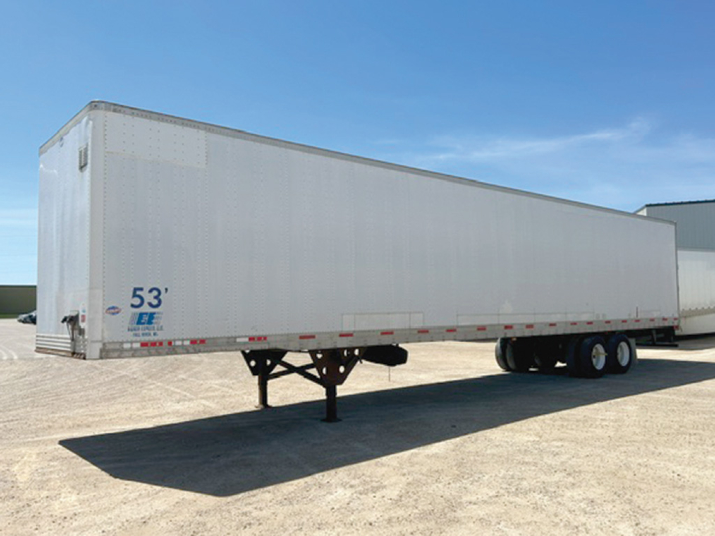 Trailer shows 53' length decal on front left side with tandem axle, gooseneck hitch trailer in a dirt lot.