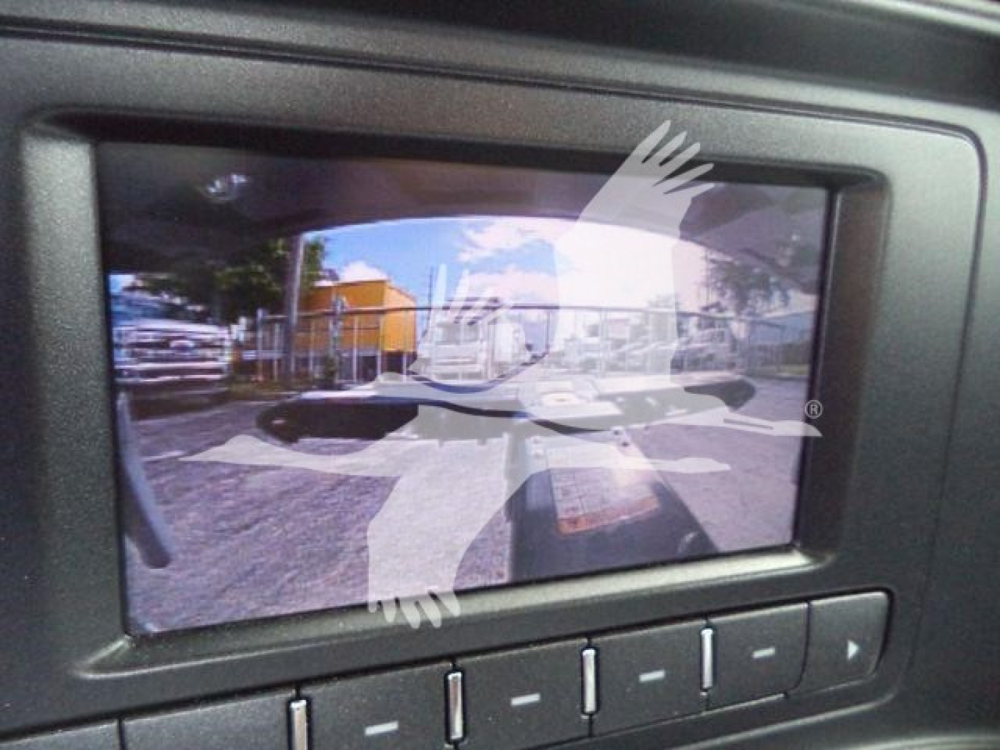 Component: backup display screen showing a camera feed with vehicles and surroundings in a parking lot.