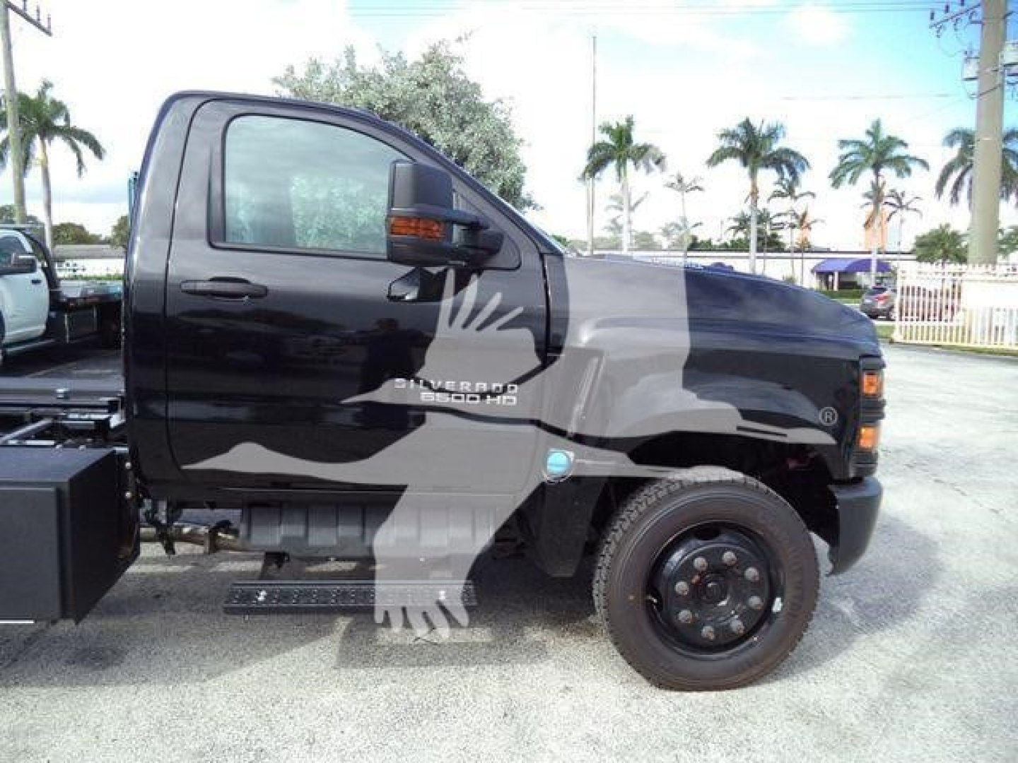 Truck side view showing Silverado 6500HD badge and black cab with step running board.