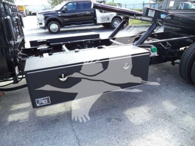Truck service bed toolbox with camouflage design mounted on a rollback chassis; Cheverolet Silverado 6500HD listing in background; toolbox lid handles visible.