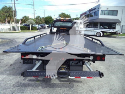 Flatbed tow truck bed on a Chevrolet Silverado 6500HD with rear lights and chains, viewed from the back.