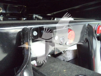 Truck hitch area showing mounting bracket and red round button on Silverado 6500HD rollback chassis.