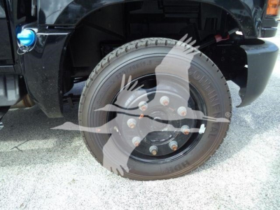 Wheel and tire close-up on a Chevrolet Silverado 6500HD rollback truck with visible lug nuts and tire sidewall details.