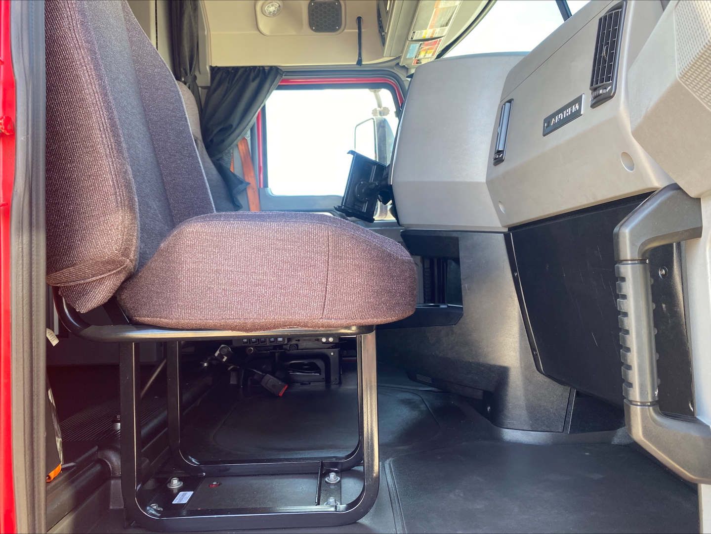 Cab interior of a 2020 Mack AN64T70 truck showing driver seat, dashboard, and entry area from a low angle.