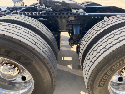 Dual rear tractor axles with suspension and tires; visible are chains, frame, and wheel hubs. No legible labels or text clearly visible in the portion shown.