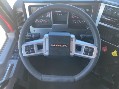 Mack AN64T70 truck cockpit steering wheel with Mack logo and instrument cluster visible.