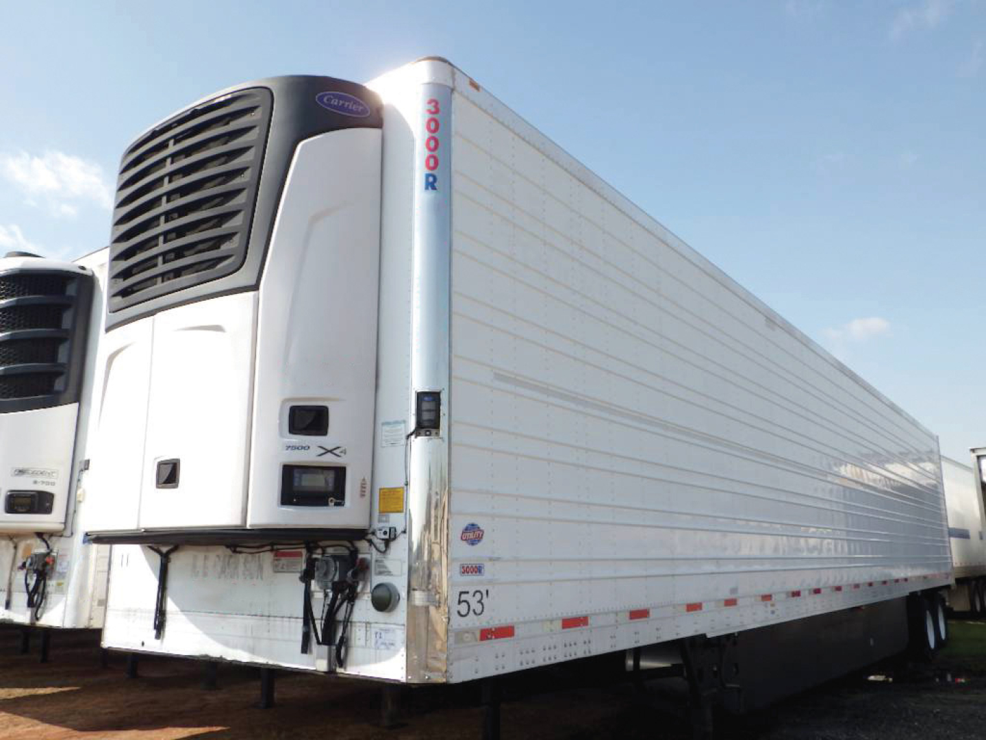 Trailer side showing 53' Utility 3000R refrigerated trailer with Carrier unit at front and VIN sticker visible