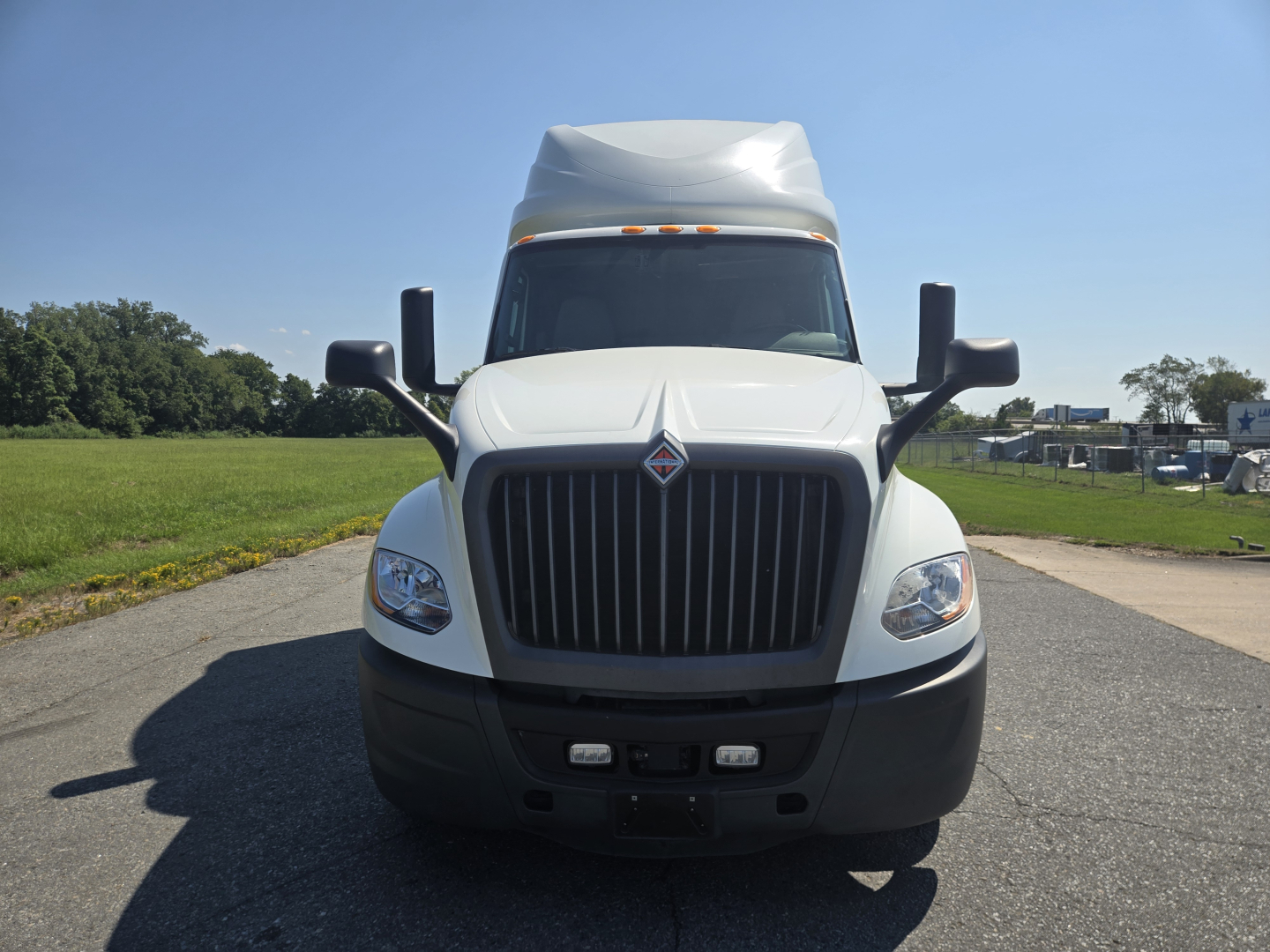Front view of a white 2021 International LT625 conventional sleeper truck showing grille, headlights, bumper, and cab mirrors.