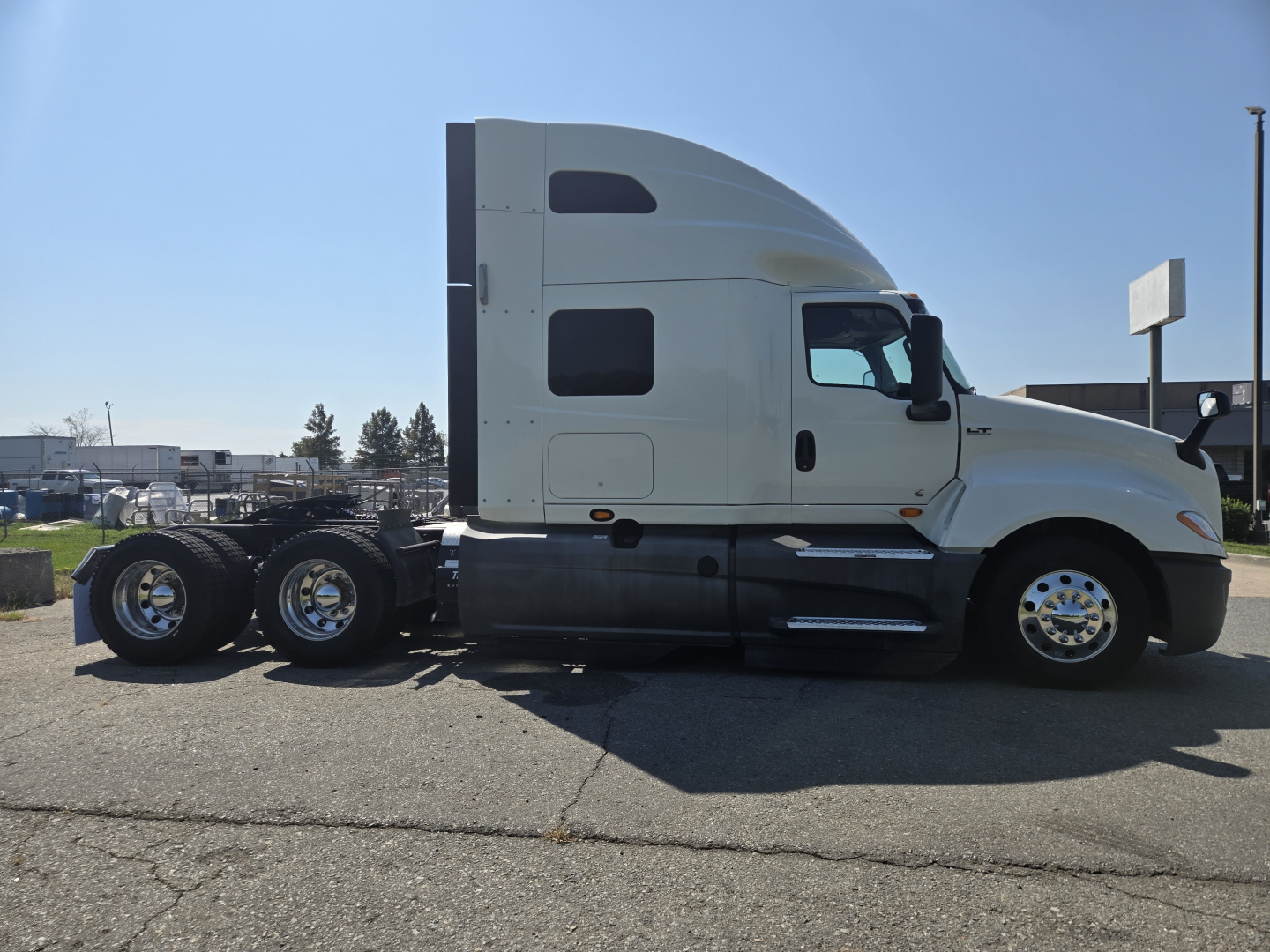 International LT625 semi-truck tractor side view showing sleeper cab and triple rear axles.