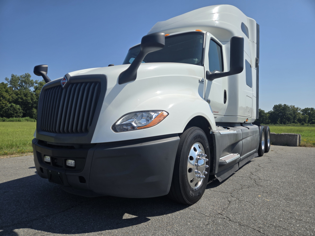 Truck cab in daylight showing International LT625 with sleeper, front grille, dual axle, no visible defects.