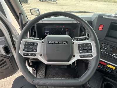 Steering wheel and cockpit view of a 2026 Mack PR64T tractor showing the Mack steering wheel with control buttons and dashboard behind.