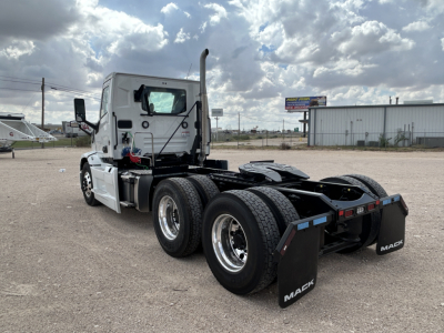 Mack PR64T tractor truck in a dealership lot, front and side view, showing cab, dual rear axles, and fifth-wheel area with mudflaps labeled 'MACK'