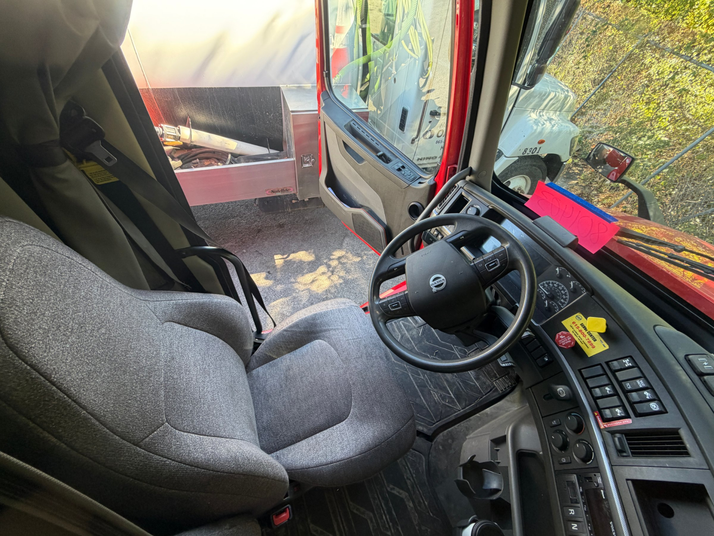 Volvo VNL64T760 truck cabin interior with steering wheel and dashboard visible.