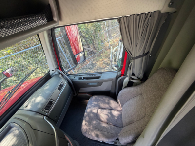 Volvo VNL64T760 sleeper cab interior showing dashboard and passenger seat with grey fabric upholstery.
