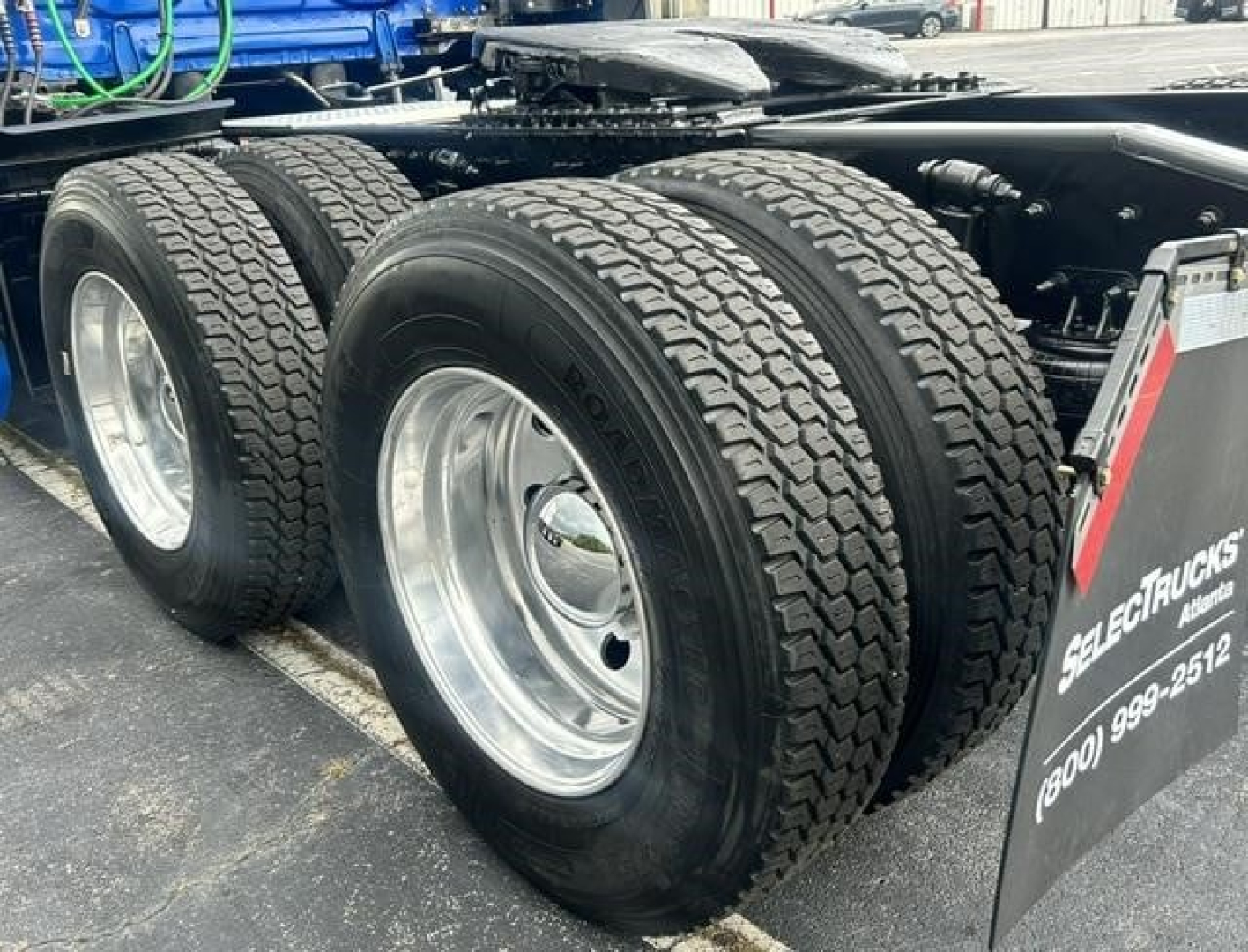 Freightliner Cascadia 126 rear dual axle with large tires and wheel rims, chassis visible.