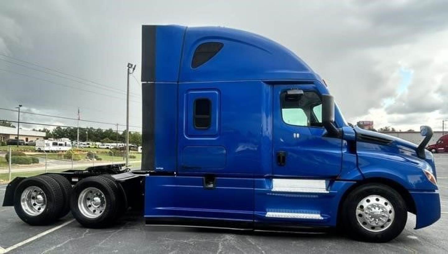 Freightliner Cascadia 126 sleeper tractor in blue, side view showing cab and tires.