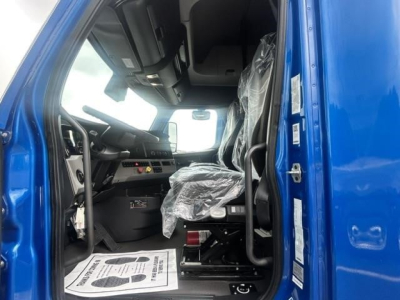 Freightliner Cascadia 126 truck interior cab view showing driver's seat and dashboard with plastic seat cover and steering wheel.