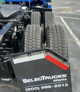 Freightliner Cascadia 126 rear wheels and mudflap showing SelectTrucks Atlanta branding and contact information.