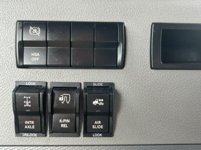 Freightliner Cascadia dash switches with HSA OFF, lock, slide, K-PIN REL, air slide controls on panel.