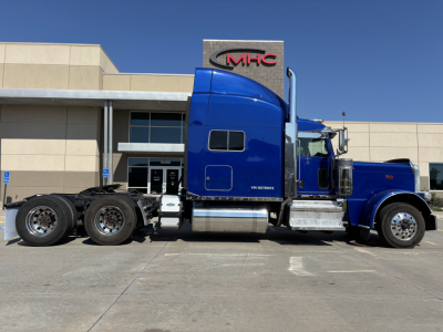 Peterbilt 389 conventional sleeper truck in blue, side view with long hood and chrome exhaust stacks.